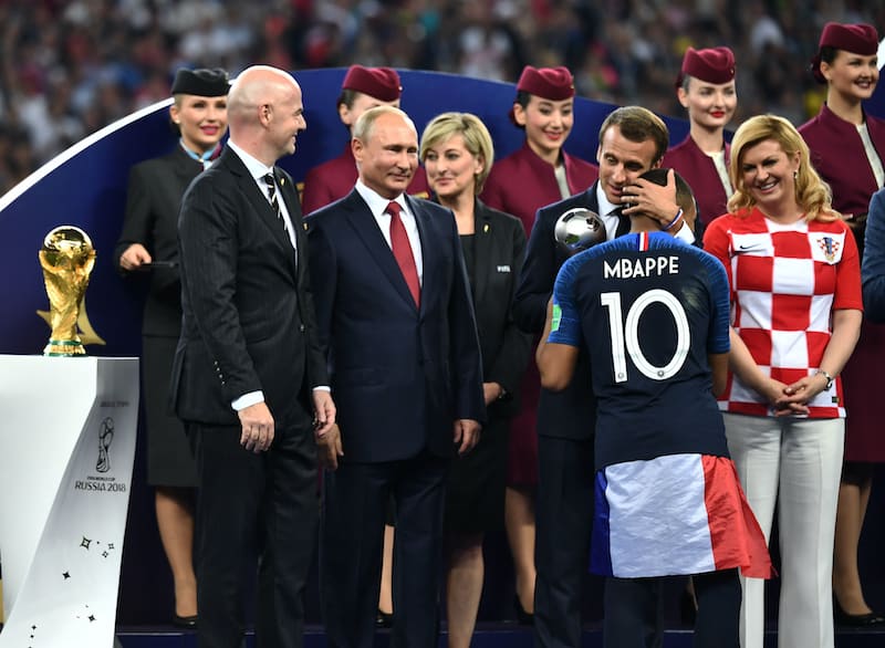 Kylian Mbappe with French President Emmanuel Macron next to FIFA president Gianni Infantino, Russian President Vladimir Putin, Croatian President Kolinda Grabar-Kitarovic and other guests