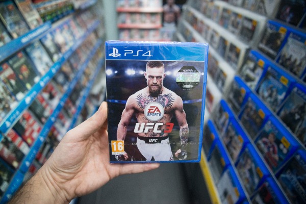 Bratislava, Slovakia, february 12, 2018: Man holding UFC 3 videogame on XBOX One console in store