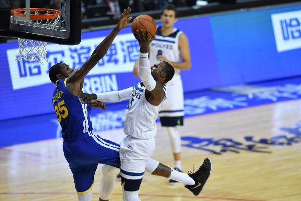 Kevin Durant, left, of Golden State Warriors, attempts to block the shot of Kris Dunn of Minnesota Timberwolves in a basketball match during the NBA China Games in Shanghai, China, 8 October 2017